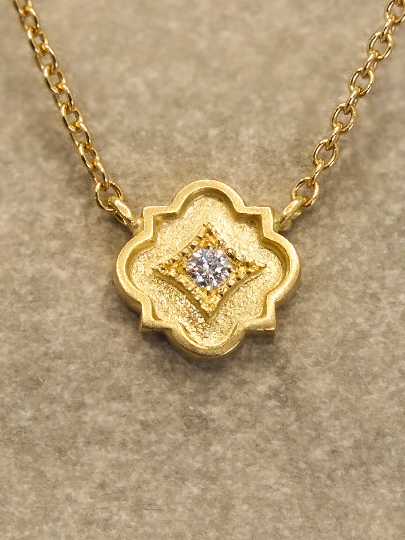 delicate 18k gold station necklace featuring a tiny quatrefoil pendant set with a sparkling diamond in a millgrain-bordered frame. Inspired by Gothic architecture and sacred geometry, this necklace is a modern talisman of light, protection, and inner radiance.